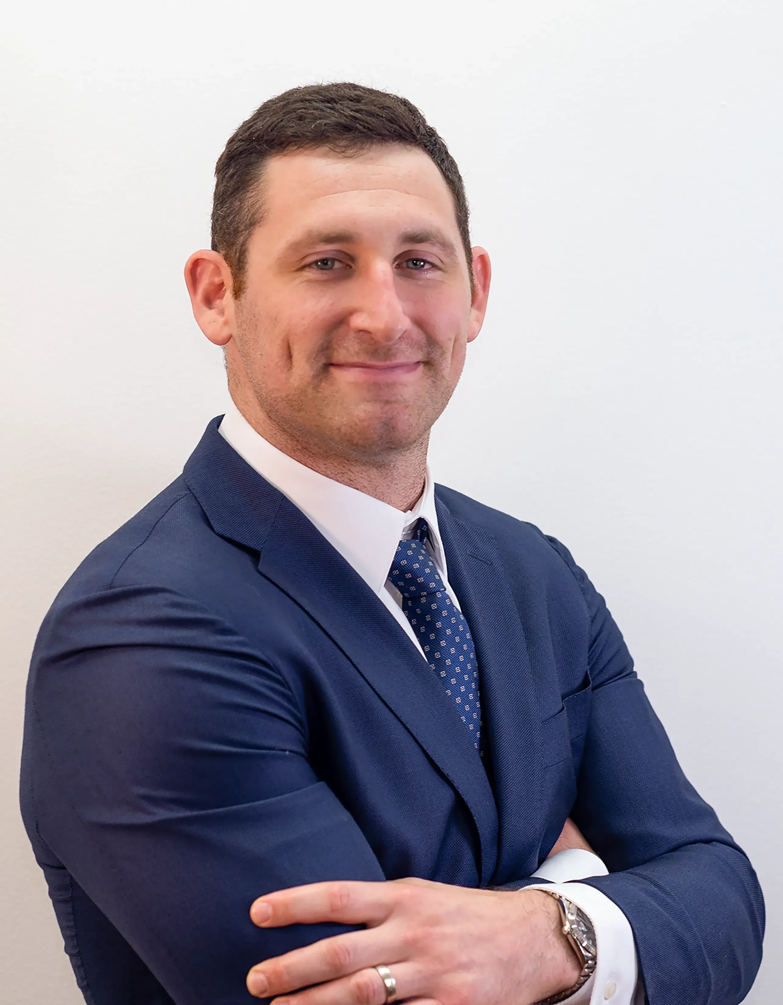 Personal injury lawyer Alex B. Senft smiling with arms crossed.
