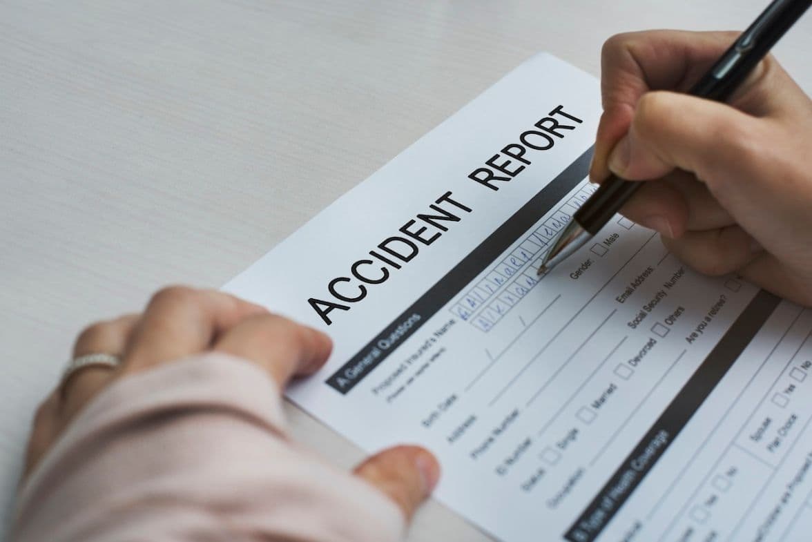Someone filing an accident report in Florida with pen and paper.